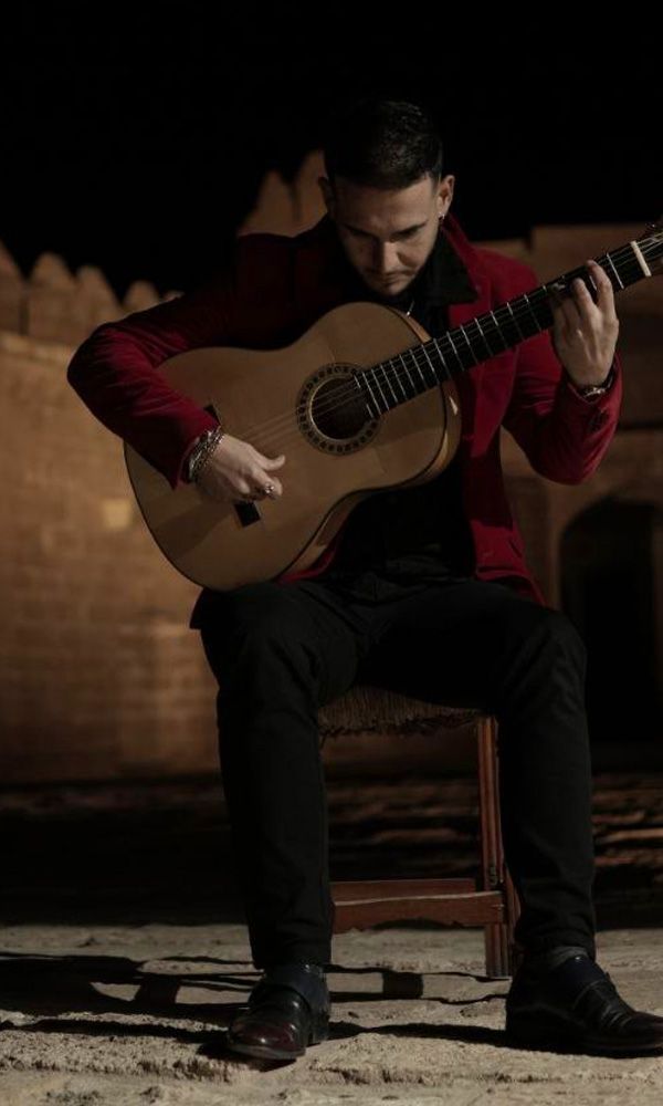 Antonio de Quero sentado tocando la guitarra